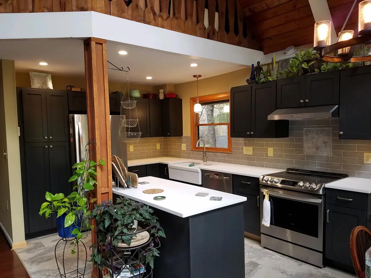 Custom cabinetry and finish carpentry detail in a charcoal kitchen